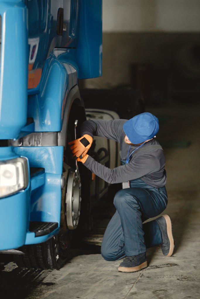 Técnico realizando manutenção na roda de um caminhão